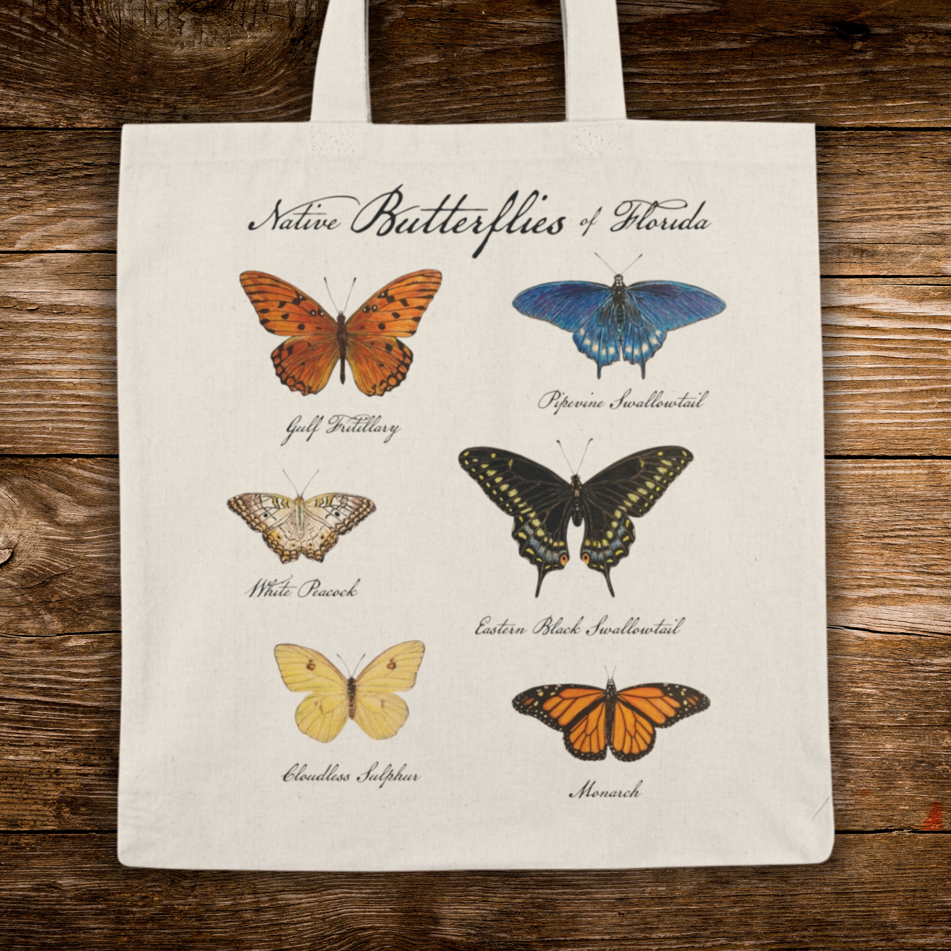 Tote bag with illustrations of butterflies of Florida on a wooden surface