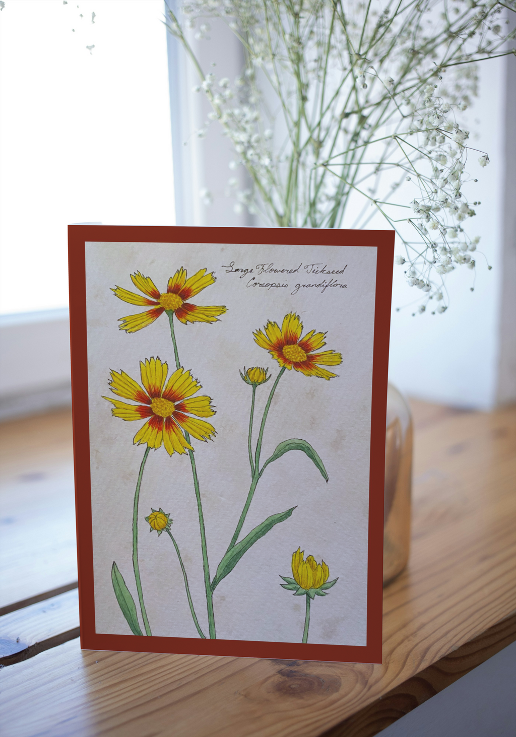 Card with floral design on a wooden surface with a blurred background