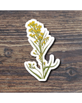 Sticker of a plant with yellow flowers on a wooden surface