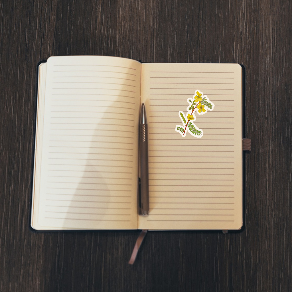 Open notebook with lined pages, a pen, and a floral sticker on a dark wooden surface