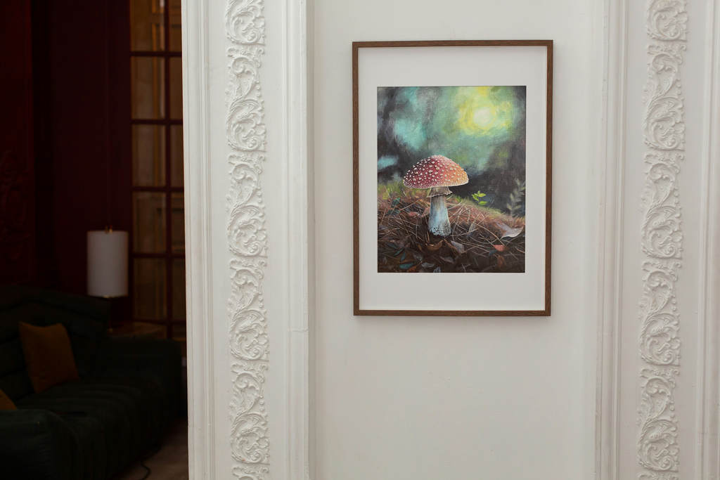 Framed print of a mushroom in a forest setting on a white wall