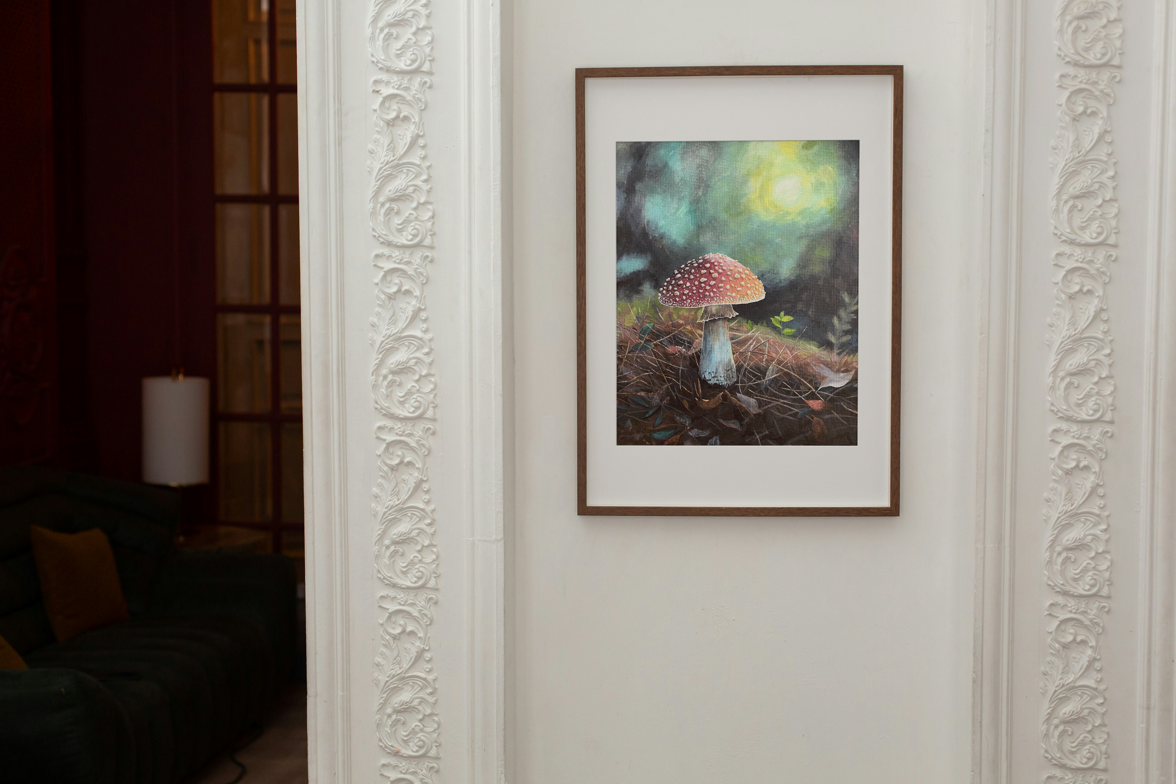 Framed print of a mushroom in a forest setting on a white wall