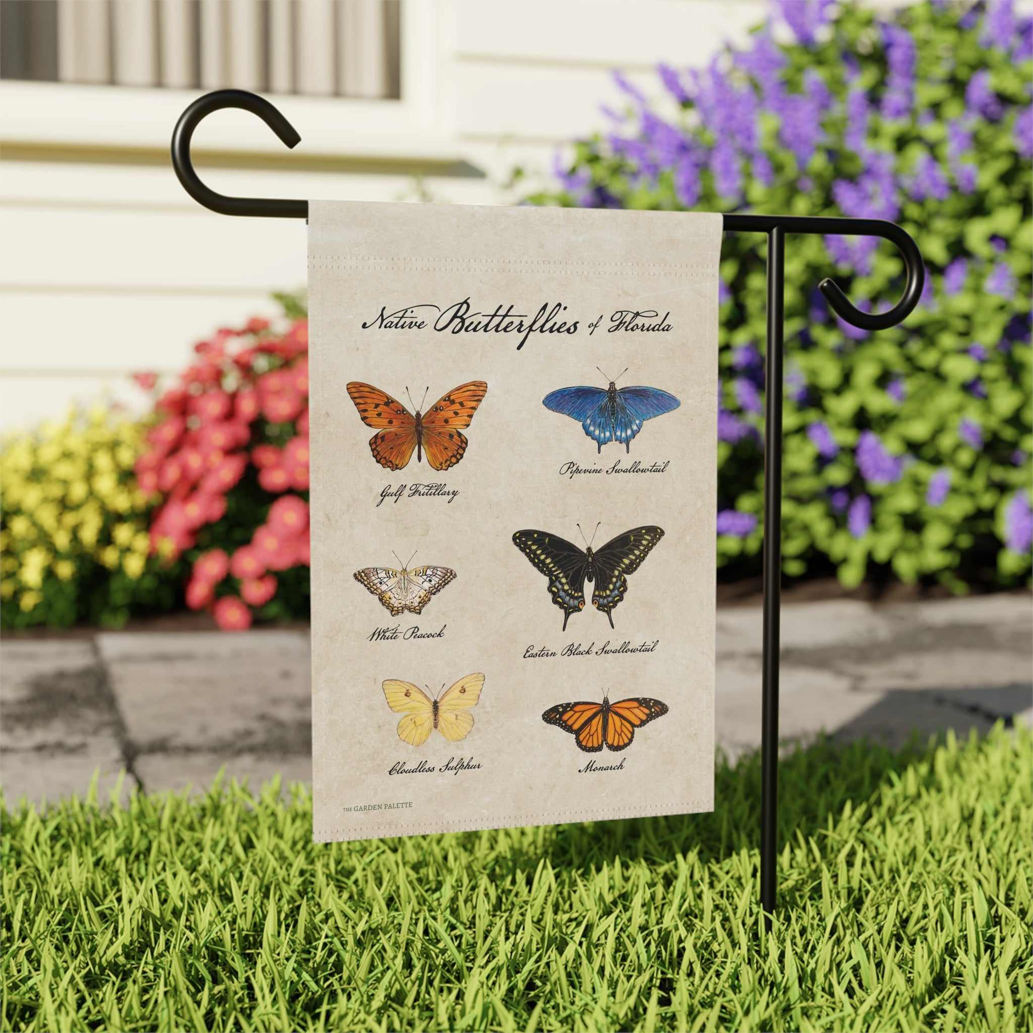 Garden flag with illustrations of butterflies on a grassy lawn.