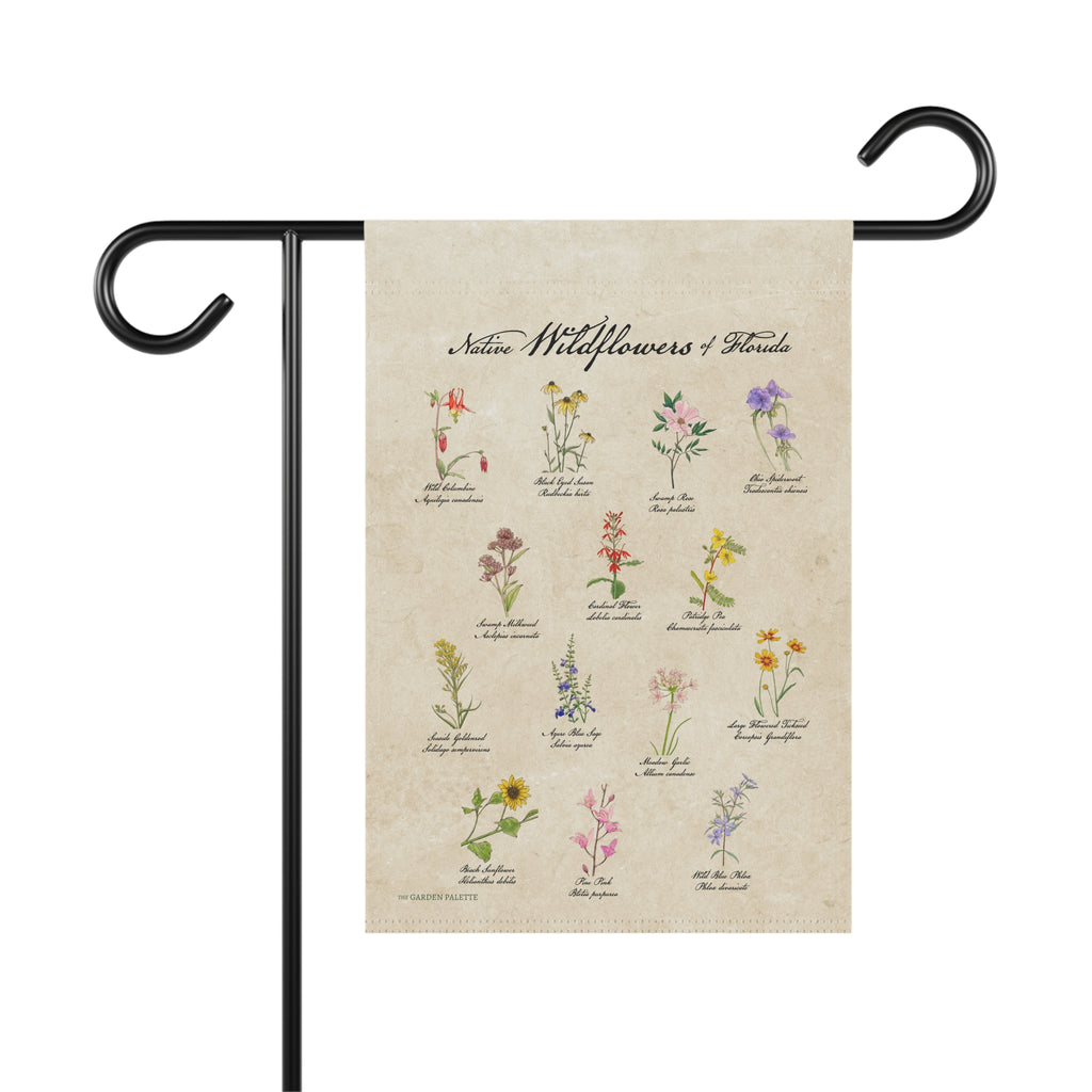 Decorative garden flag with illustrations of wildflowers on a beige background, attached to a black metal flagpole.