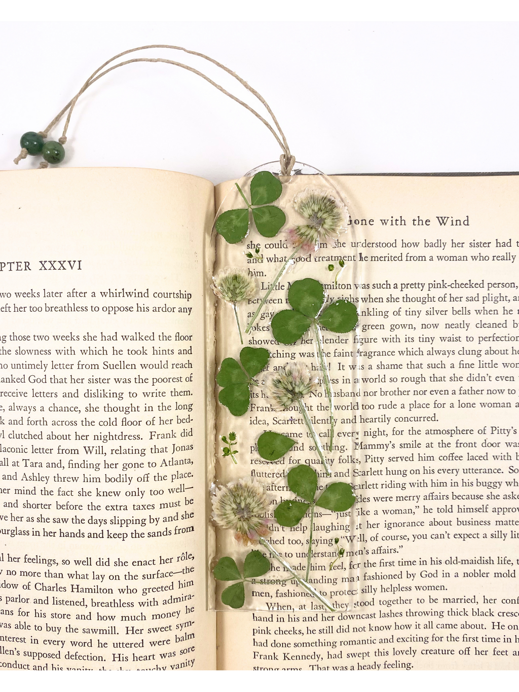A bookmark featuring clover flowers and leaves, displayed on an open book.
