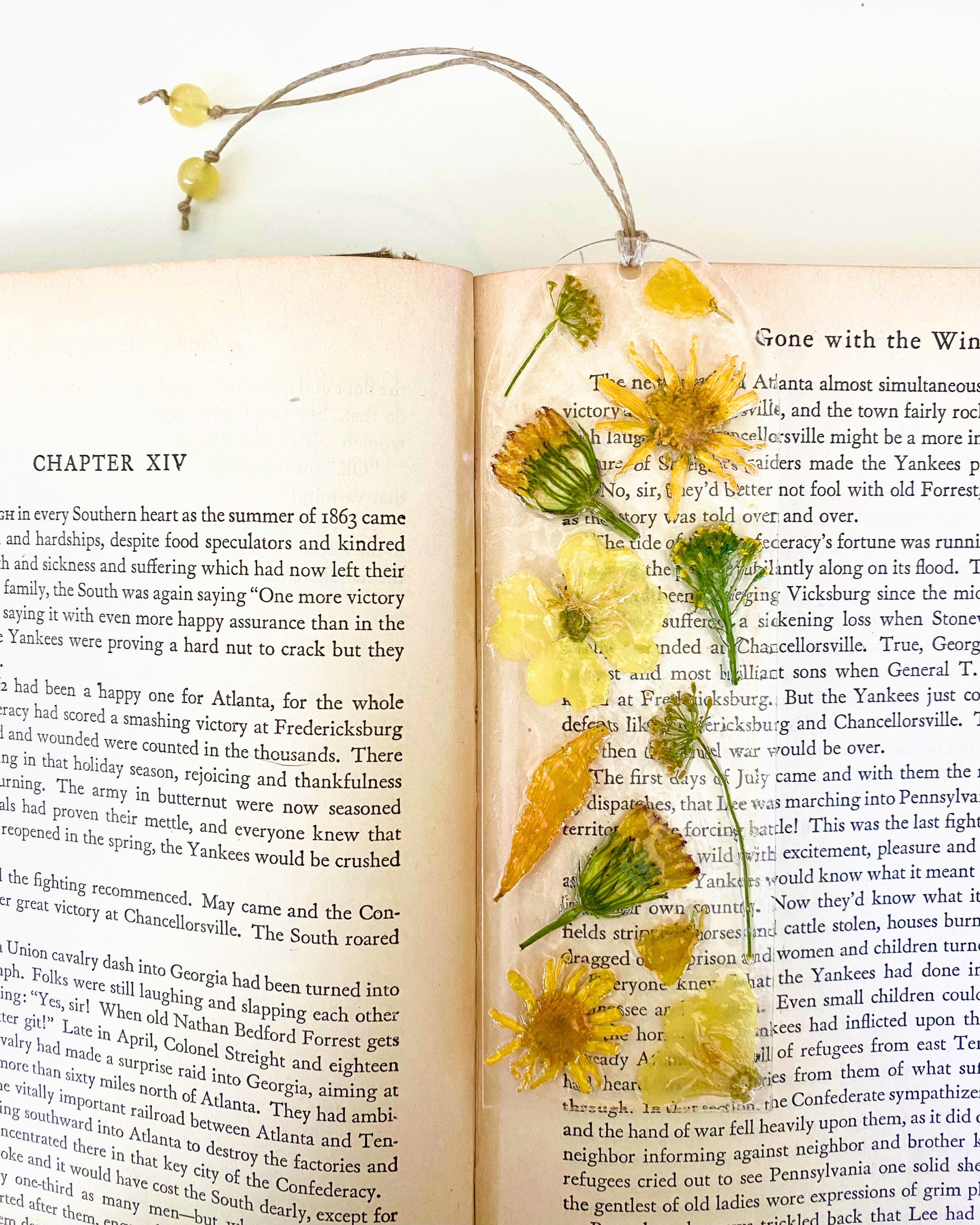 A bookmark with yellow flowers on an open book