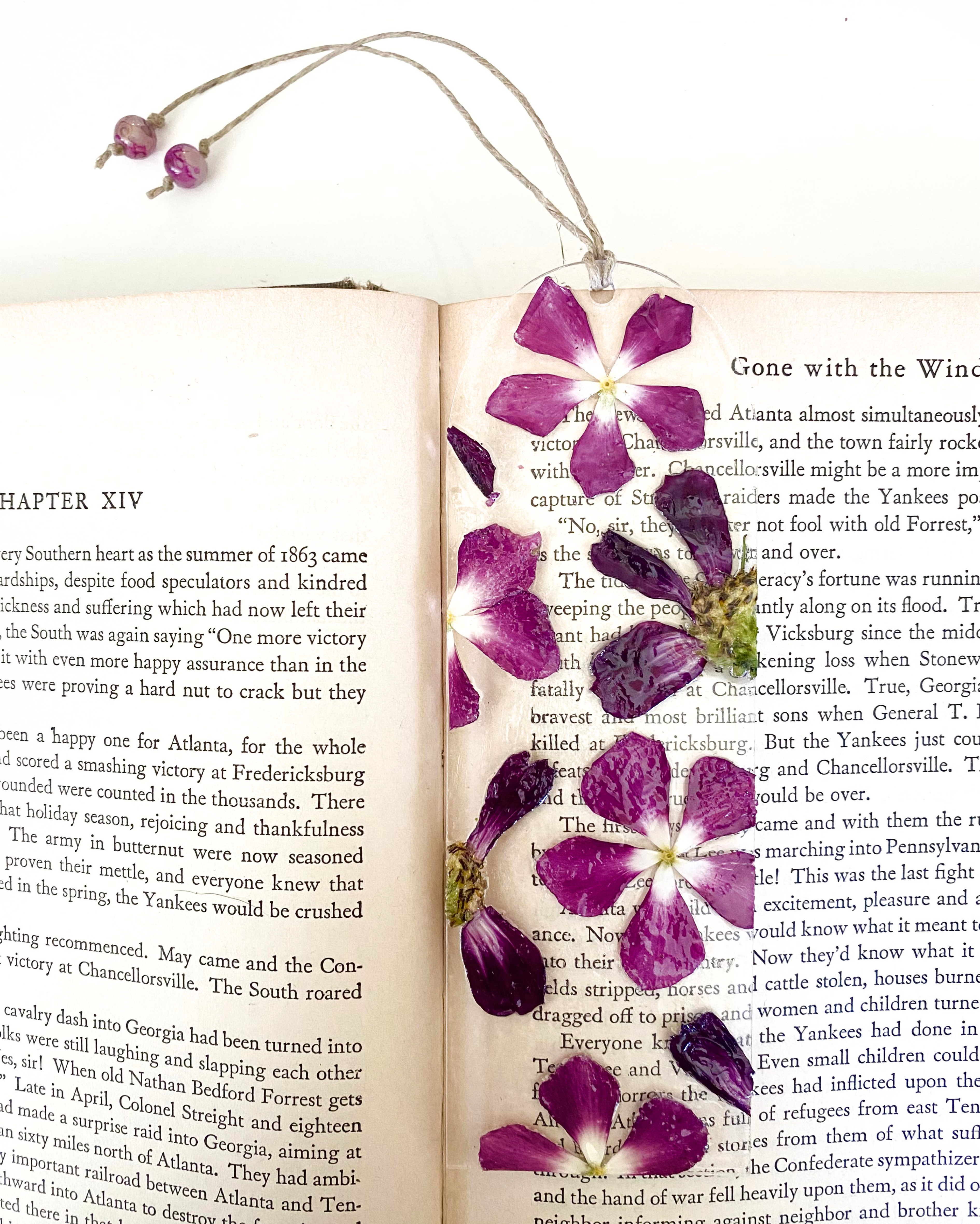 A bookmark with purple flowers on an open book