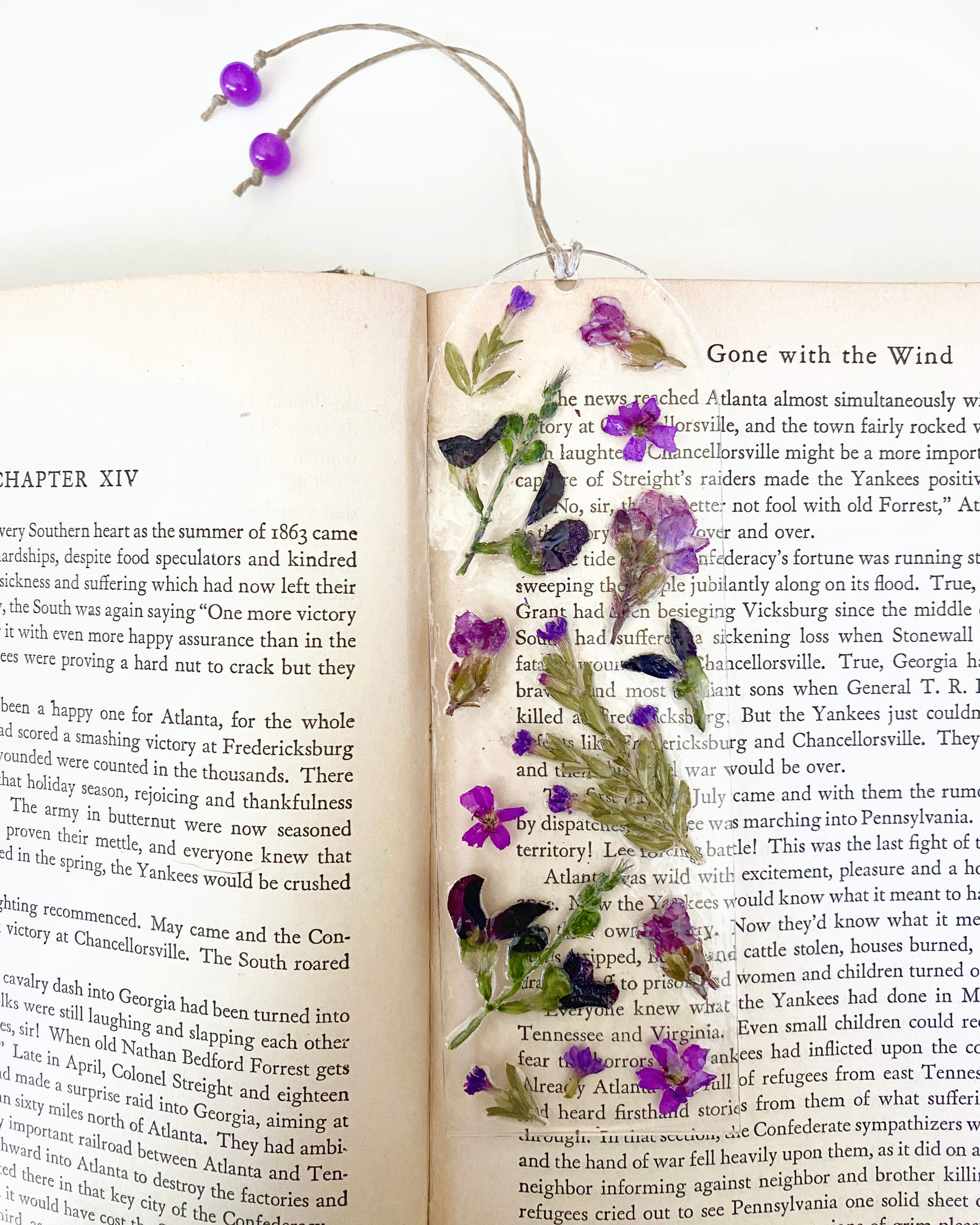 A bookmark with purple flowers on an open book