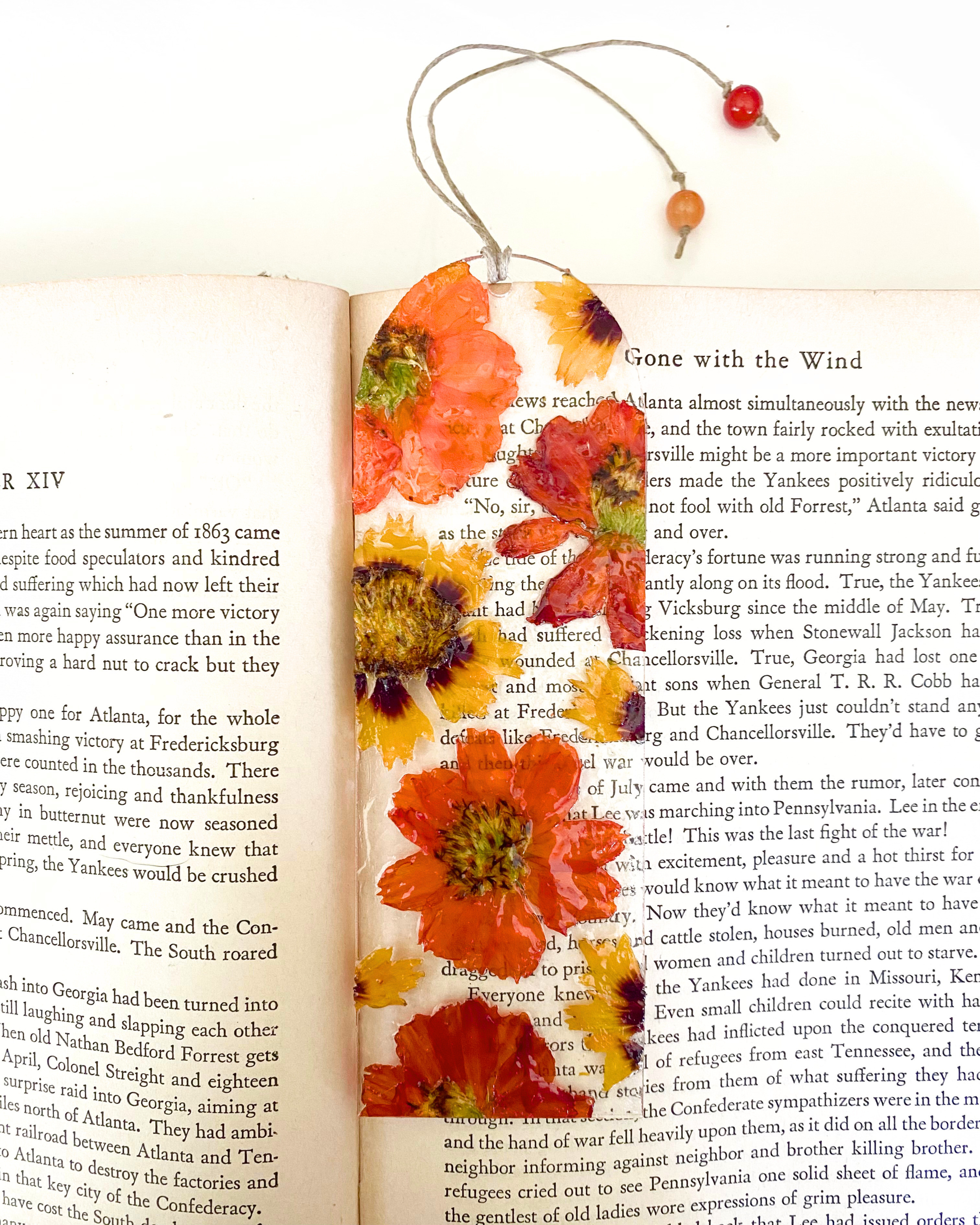 A bookmark with orange flowers on an open book